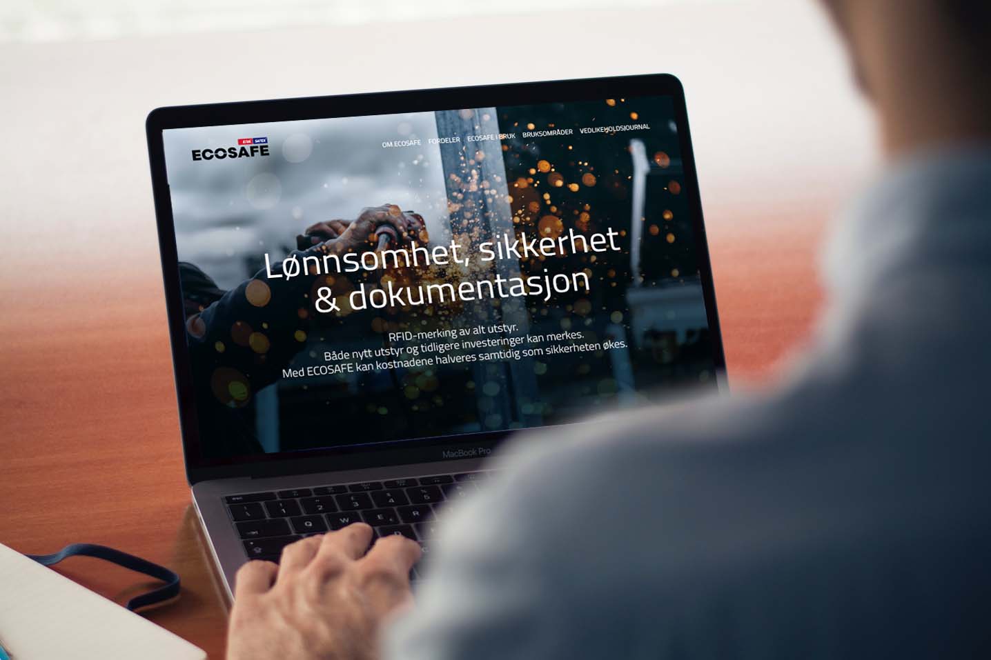 Foto av mann med PC, PCen viser ECOSAFE sin webside.