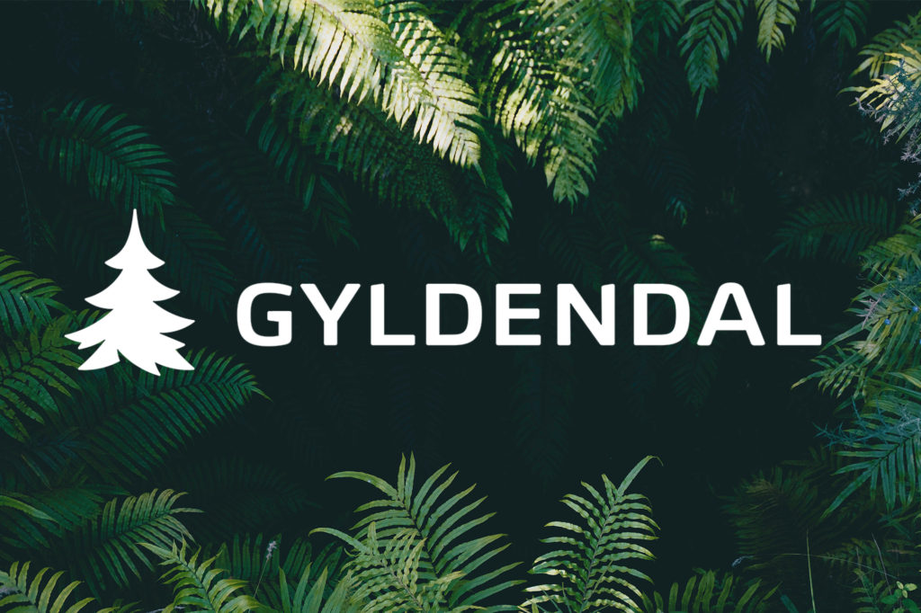 Gyldendals logo i hvitt på foto av planter