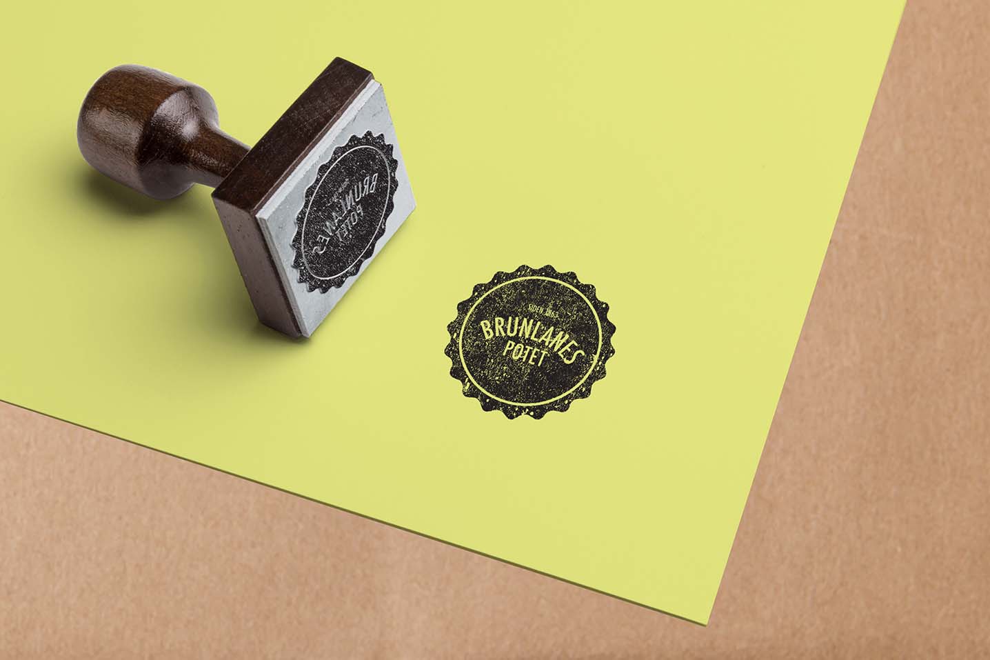 Gult ark på beige bakgrunn med sort stempel. Stempelet er en sirkel med teksten Brunlanespotet siden 1863
